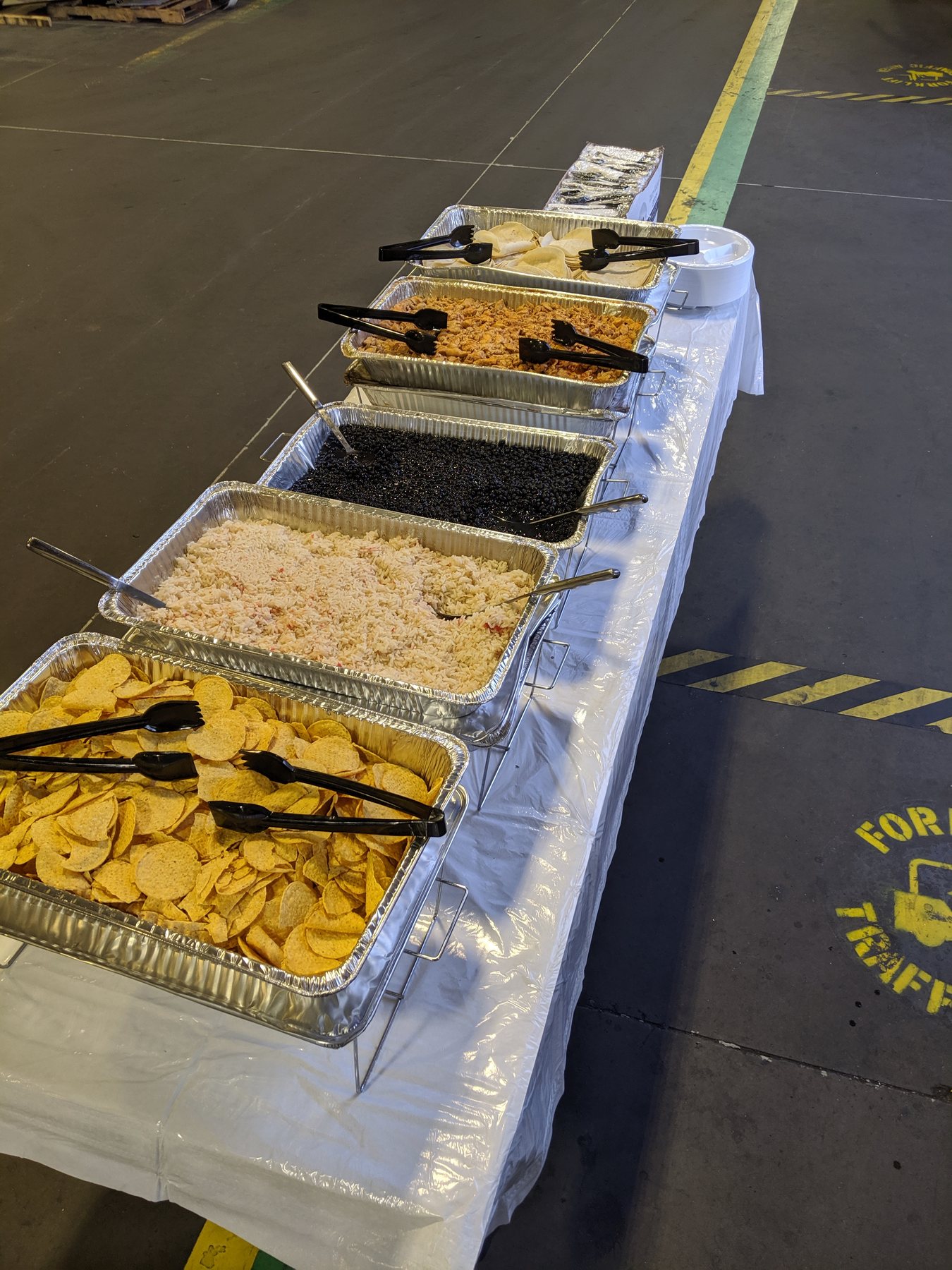 Trays of rice, vegetables and fried dishes set out along a catering buffet line
